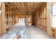 Exposed wood framing in the unfinished living room with large windows, construction materials and open floor plan at 3353 Hemphill St, Atlanta, GA 30337