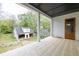 Open porch with brick flooring overlooks a spacious backyard and a detached garage, offering a blend of relaxation and practicality at 3353 Hemphill St, Atlanta, GA 30337