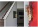 Front entryway with red door, stairway, mirror and a glimpse into the living room at 615 Old Johnson Rd, Lawrenceville, GA 30045