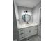 Modern bathroom featuring a round mirror, white vanity, and stylish black fixtures at 912 Holden Ln, Atlanta, GA 30349
