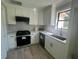 Modern kitchen featuring white cabinets, stainless steel appliances, and a black backsplash at 912 Holden Ln, Atlanta, GA 30349
