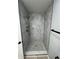 Modern shower with marbled tile, hexagon floor, and gold fixtures at 912 Holden Ln, Atlanta, GA 30349
