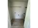 This utility closet features updated wood-style vinyl flooring, a storage shelf, and connections for laundry appliances at 912 Holden Ln, Atlanta, GA 30349