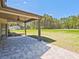 Paver patio and covered porch overlooking a large grassy yard and wooded area at 125 Leverett Ct, Fayetteville, GA 30215