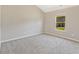 This bedroom features neutral carpet, large window with wooded view, and light-colored walls at 125 Leverett Ct, Fayetteville, GA 30215