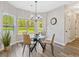 Bright breakfast nook featuring a glass table, modern chairs, large windows, and wood flooring at 125 Leverett Ct, Fayetteville, GA 30215