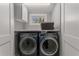 Modern laundry room featuring a full-size washer and dryer, upper cabinets, and a view from the window at 1285 Oakdale Ne Rd, Atlanta, GA 30307