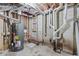 Utility area with water heater, pipes, and exposed concrete walls at 2241 Glendale Dr, Decatur, GA 30032