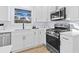 Modern kitchen with white cabinets, stainless steel appliances, quartz countertops, and a view to the backyard at 2241 Glendale Dr, Decatur, GA 30032