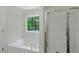 Bathroom showcasing a garden tub beneath a window next to a glass enclosed shower at 3131 Leyland Ct, Decatur, GA 30034