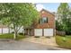 Traditional brick home featuring an attached two car garage and mature tree at 3131 Leyland Ct, Decatur, GA 30034