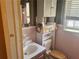 Bathroom with pink tiling, white toilet, and cabinet at 2019 Thomasville Se Dr, Atlanta, GA 30315