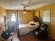Bedroom with four-poster bed, ceiling fan, wood floor and sitting area near a window with natural light at 2019 Thomasville Se Dr, Atlanta, GA 30315