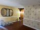 Living room featuring hardwood floors, vintage wallpaper, and three decorative mirrors at 2019 Thomasville Se Dr, Atlanta, GA 30315