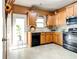 View of the kitchen with wooden cabinets, black appliances, and a door that leads to the backyard at 2904 Ridgeview Sw Dr, Atlanta, GA 30331
