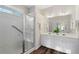 Bright bathroom featuring double vanity with white cabinets and a tiled shower with glass door at 3915 Deerborne Dr, Cumming, GA 30040