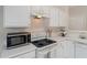 Close-up showcases sleek black microwave and electric stove in a tidy white kitchen at 3915 Deerborne Dr, Cumming, GA 30040