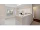 View of kitchen with white cabinets and appliances leading into the dining area at 3915 Deerborne Dr, Cumming, GA 30040