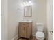 Cozy half bath with decorative mirror and wood vanity at 5620 Weddington Drive Dr, Cumming, GA 30040
