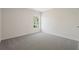 Bedroom with neutral-colored walls and carpet and a window with a view of a tree at 5620 Weddington Drive Dr, Cumming, GA 30040