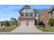 Charming two-story home with a brick and siding exterior, two-car garage, and well-maintained front lawn at 5620 Weddington Drive Dr, Cumming, GA 30040