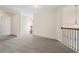 Upstairs hallway featuring neutral carpeting, a wrought iron railing, and a decorative light fixture at 5620 Weddington Drive Dr, Cumming, GA 30040