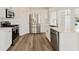 Modern kitchen featuring white cabinets, stainless steel appliances, quartz countertops, and hardwood floors at 5620 Weddington Drive Dr, Cumming, GA 30040
