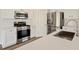 Stylish kitchen featuring white cabinets, stainless steel appliances, quartz countertops, and modern fixtures at 5620 Weddington Drive Dr, Cumming, GA 30040