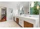 Modern bathroom features a floating double sink vanity, marble floors, and a large window overlooking the backyard at 123 Peachtree Cir, Atlanta, GA 30309