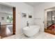 Sleek white soaking tub centered in a modern bathroom with white marble floors and minimalist decor at 123 Peachtree Cir, Atlanta, GA 30309