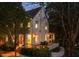 Charming exterior view of a two-story home with a walkway, manicured bushes, and inviting, well-lit front porch at 123 Peachtree Cir, Atlanta, GA 30309