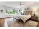 Spacious main bedroom with a large window and a bench at the foot of the bed, overlooking the neighborhood at 123 Peachtree Cir, Atlanta, GA 30309