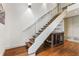 Modern staircase features wood steps, glass railing, and a stylish dog crate underneath with a dog bed at 123 Peachtree Cir, Atlanta, GA 30309