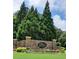 Stone entrance to 'The Georgian' neighborhood with lush landscaping and mature trees providing a welcoming ambiance at 15 Masters Dr, Villa Rica, GA 30180