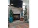 Living room with a brick fireplace and a big screen TV above, decorated with Christmas trees at 15 Masters Dr, Villa Rica, GA 30180