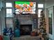 Living room with fireplace and a big screen TV with football game playing and Christmas decorations at 15 Masters Dr, Villa Rica, GA 30180