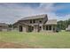 Wide backyard view featuring the home's exterior, a covered patio, and lush green lawn at 21 Homesite Cooper E Cv, Fayetteville, GA 30215