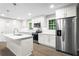 Beautiful white kitchen with an island, stainless steel refrigerator, and modern pendant lighting at 2310 Rubart Dr, Marietta, GA 30066