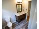 Bathroom with vanity with a solid surface top and a wood-look framed mirror at 670 Maplelake Dr, Acworth, GA 30101