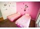 Pink bedroom featuring two twin beds, Minnie Mouse decor, and a warm, inviting atmosphere at 670 Maplelake Dr, Acworth, GA 30101