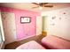Charming pink bedroom with television, two twin beds, ceiling fan, and playful Minnie Mouse wall decor at 670 Maplelake Dr, Acworth, GA 30101