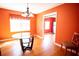 Dining room with orange walls featuring a glass table with hardwood floors at 670 Maplelake Dr, Acworth, GA 30101