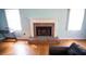 Close up of a cozy fireplace with brick surround, complemented by hardwood floors and ample natural light at 670 Maplelake Dr, Acworth, GA 30101
