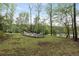 Backyard with firepit and ample seating surrounded by mature trees and foliage at 7650 Rico Rd, Chattahoochee Hills, GA 30268