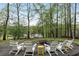 Cozy backyard with firepit and seating surrounded by lush trees and a waterfront view at 7650 Rico Rd, Chattahoochee Hills, GA 30268