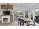 Eat-in kitchen/dining area with stone fireplace, TV, screened patio access and outside views at 7650 Rico Rd, Chattahoochee Hills, GA 30268
