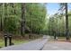 Gated entrance to a private property, surrounded by a lush forest and mature trees at 7650 Rico Rd, Chattahoochee Hills, GA 30268