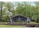 Charming single-story home with a screened-in porch and lush landscaping, nestled among mature trees at 7650 Rico Rd, Chattahoochee Hills, GA 30268