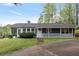Quaint single-story home with a screened-in porch, white railing and stone pathway at 7650 Rico Rd, Chattahoochee Hills, GA 30268