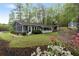Charming home exterior with a screened porch, well-maintained lawn, and lush landscaping showcasing curb appeal at 7650 Rico Rd, Chattahoochee Hills, GA 30268